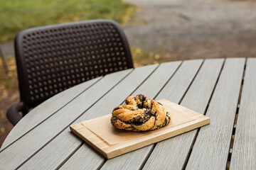 A poppyseed bun on a wooden board