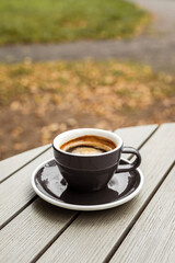 A cup of black coffee on the table of a cafe or bakery terrace