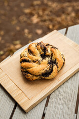 A poppyseed bun on a wooden board
