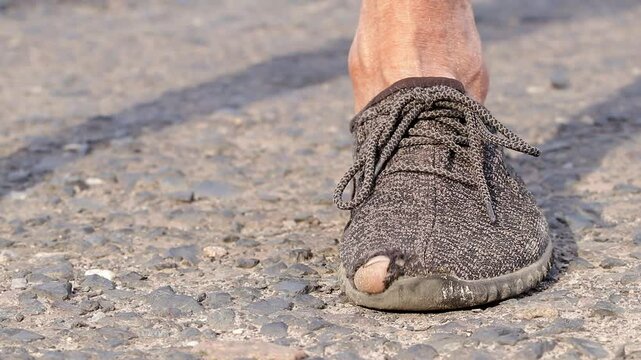 Shoes with holes.Men's worn-out moccasins with a hole and a protruding toe.The concept of poverty, misery.