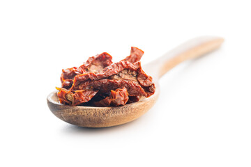 Sun dried red tomatoes on wooden spoon isolated on white background.
