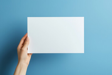 Fototapeta premium Hand holding a blank white paper