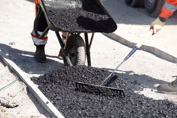 Workers Skillfully Laying Fresh Asphalt on a Sunny Day at a Construction Site in the City