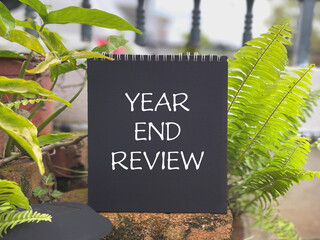 Motivational and inspirational new year concept. YEAR END REVIEW written on a notepad.