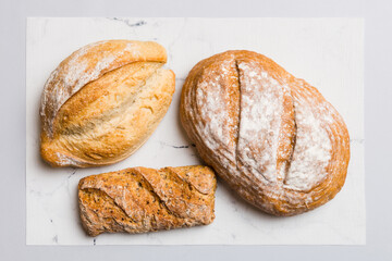 Assortment of freshly baked bread with napkin on rustic table top view. Healthy unleavened bread. French bread