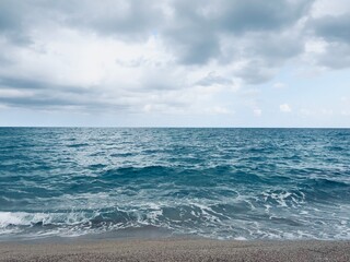 View on the shore of the beach on a cloudy day with a storm approaching.