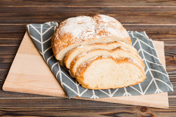 Assortment of freshly sliced baked bread with napkin on rustic table top view. Healthy unleavened bread. French bread slice