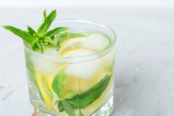 Mojito summer refreshing cocktail with ice and mint. mojito cocktail with lime, lemon and mint in a tall glass with a stick
