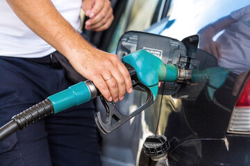 The gas station. A man refuels a car with gasoline. A Russian fuel dispenser in the fuel tank of a...