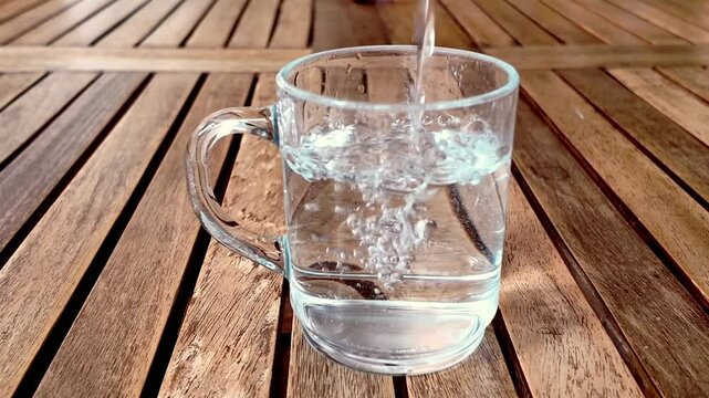 Llenando un vaso de agua sobre una mesa