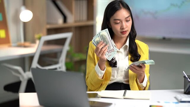 Asian businesses women working in the office used laptop and smartphone at her dest 