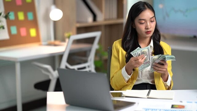 Asian businesses women working in the office used laptop and smartphone at her dest 
