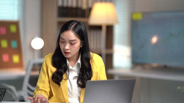 Asian businesses women working in the office used laptop and smartphone at her dest 