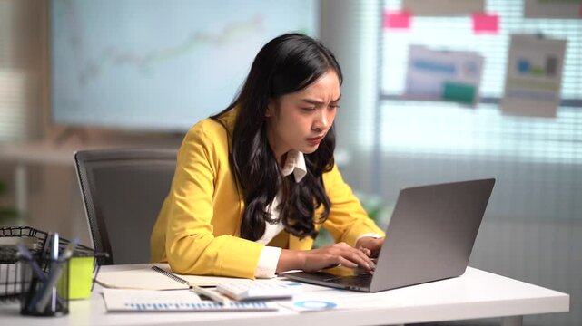 Asian businesses women working in the office used laptop and smartphone at her dest 