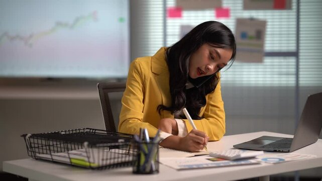 Asian businesses women working in the office used laptop and smartphone at her dest 