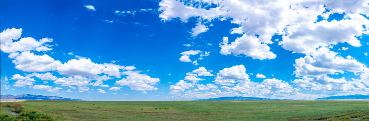 Panoramic view of sky with clouds over green field. Beautiful landscape with fluffy clouds....