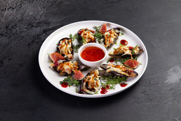 Baked mussels in a plate. on a dark background.