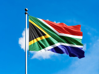 South Africa flag flying on blur blue clouds background.