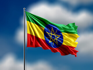 Ethiopia flag flying on blur blue clouds background.