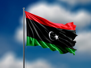 Libya flag flying on blur blue clouds background.