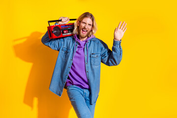 Photo of nice young man dance boombox wear denim jacket isolated on yellow color background