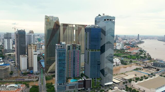 Aerial drone orbits high rise buildings at Koh Pich Island, cityscape and river views in Phnom Penh.