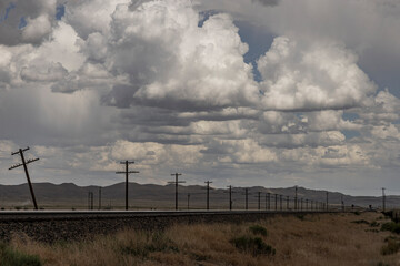 Dramatic clouds over train tracks and telegraph poles