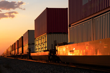 The red glow of sunset on a passing container stack train