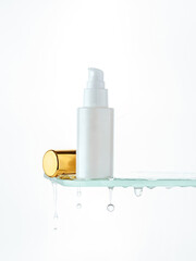 Cosmetic bottle on a glass shelf with running water