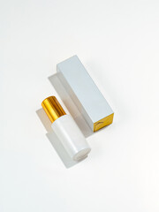 Cosmetic bottle with a gold lid on a white background with a sha