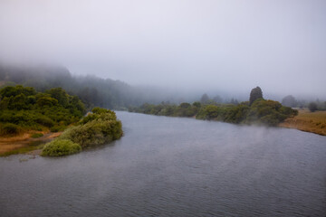 Water evaporates off river during foggy day on California coast