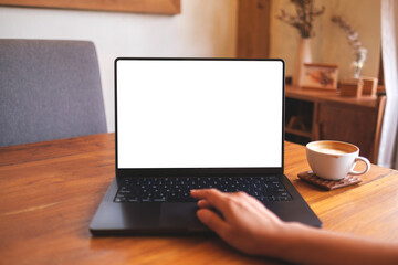 Mockup image of a woman using and touching on computer laptop touchpad with blank desktop screen at...