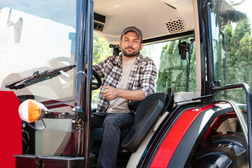 Portrait of adult man tractor driver. Agricultural machinery and farmer. © Igor Barilo