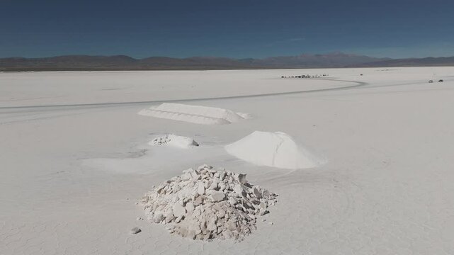 Aerial view of salt piles prepared for extraction at Salinas Grandes, located in Jujuy, Salta. The scene captures the organized mounds of salt against the expansive white landscape.