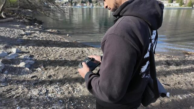 Drone operator pilot operating controller outdoor, flying the drone, nature
