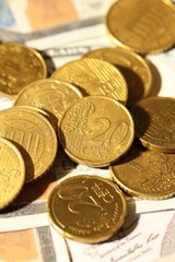 Many euro coins on dollar banknotes, closeup