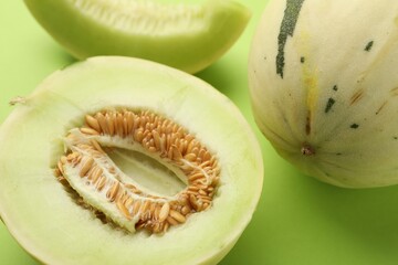 Fresh ripe honeydew melons on green background, closeup