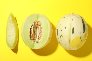 Fresh ripe honeydew melons on yellow background, top view