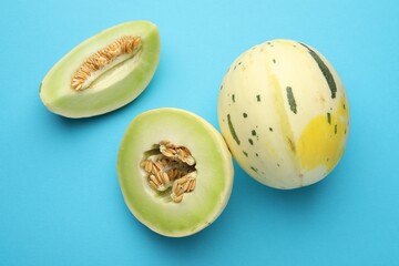 Fresh ripe honeydew melons on light blue background, top view