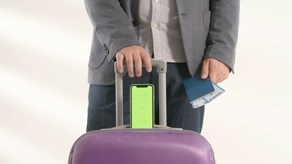 Traveling business man tourist with suitcase and smartphone chroma key green screen in...