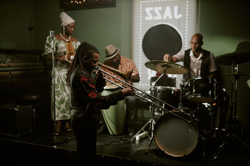 Wide shot of modern jazz band musicians preparing for performance in bar, setting instruments and checking sound