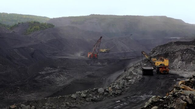 Coal mining in open pits uses various techniques to extract valuable resources from the earth. Stock Clip