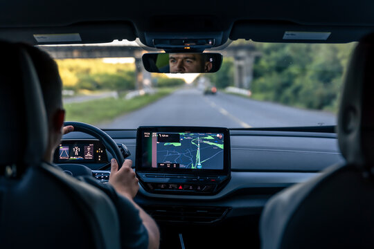 Man touching screen of a GPS navigation system in his car.