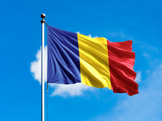 Romania flag flying on blur blue clouds background.
