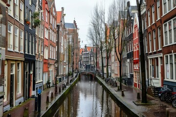 Quaint canal running through the center of amsterdam, with traditional houses and bridges lining the waterfront