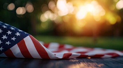 A close-up of an American flag draped on a surface, with a warm sunset in the background creating a patriotic atmosphere.