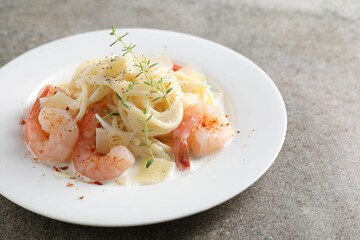 Delicious pasta with shrimps and cheese on grey table, closeup