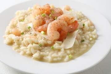 Delicious risotto with shrimps and cheese on table, closeup