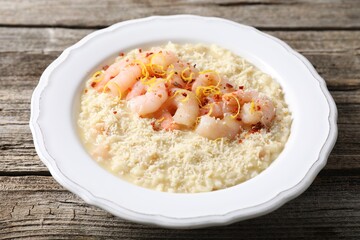 Delicious risotto with shrimps and cheese on wooden table, closeup