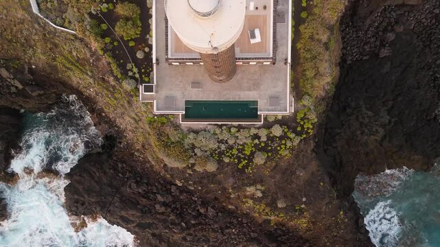 Aerial view of the rugged coastline featuring Faro de Punta Cumplida lighthouse and banana trees, Lomo Machin, La Palma, Spain.